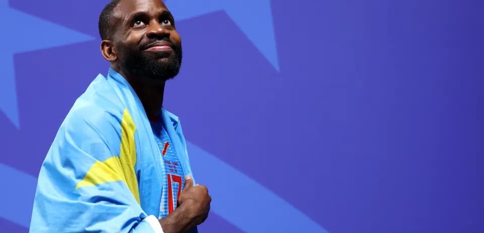 Athlete wearing a blue and yellow flag, looking up