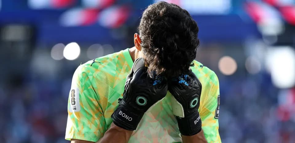 Goalkeeper holding head with gloves on field