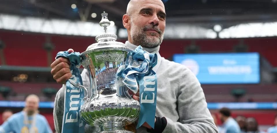 Coach holding trophy at Wembley Stadium celebration