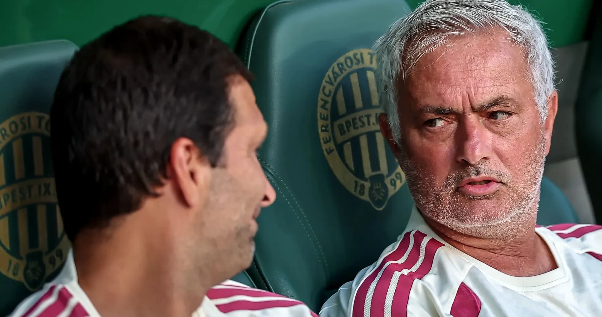 Two coaches discussing on team bench