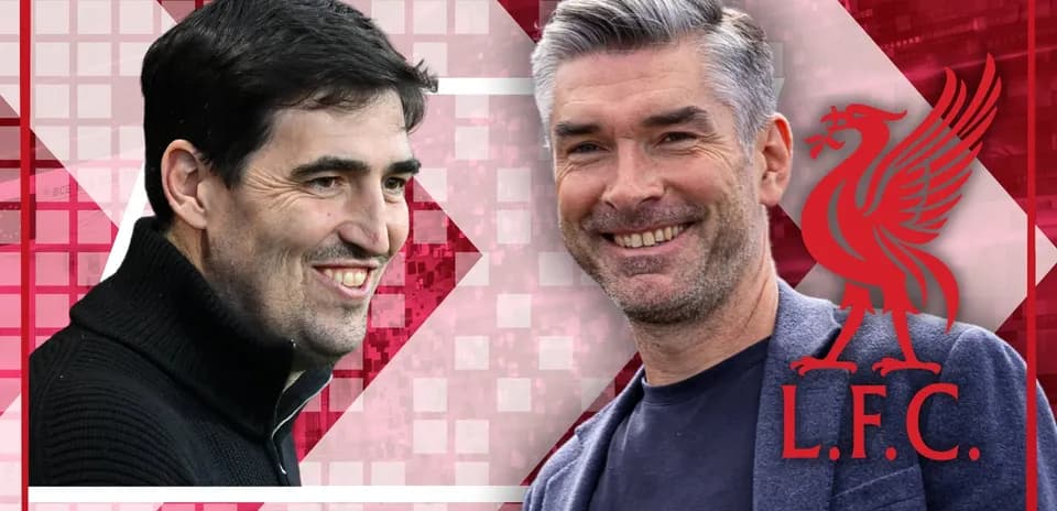 Two coaches smiling with Liverpool logo in background
