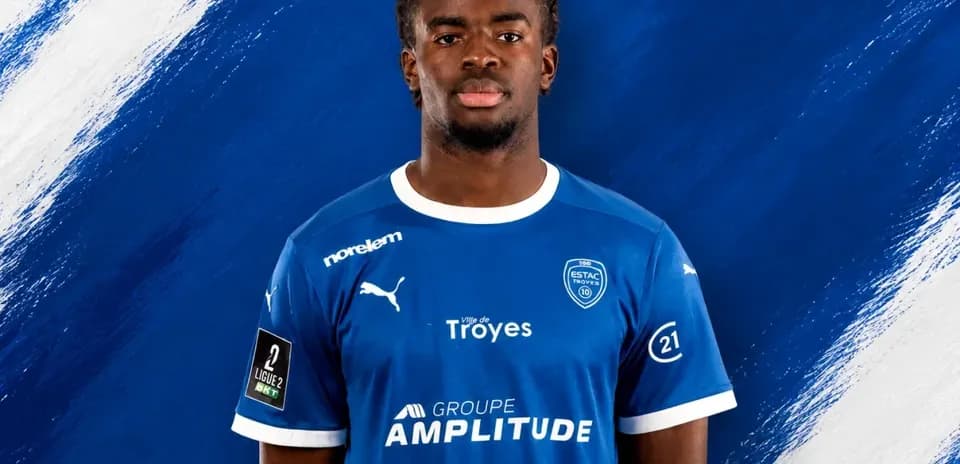 Player in blue ESTAC Troyes jersey posing