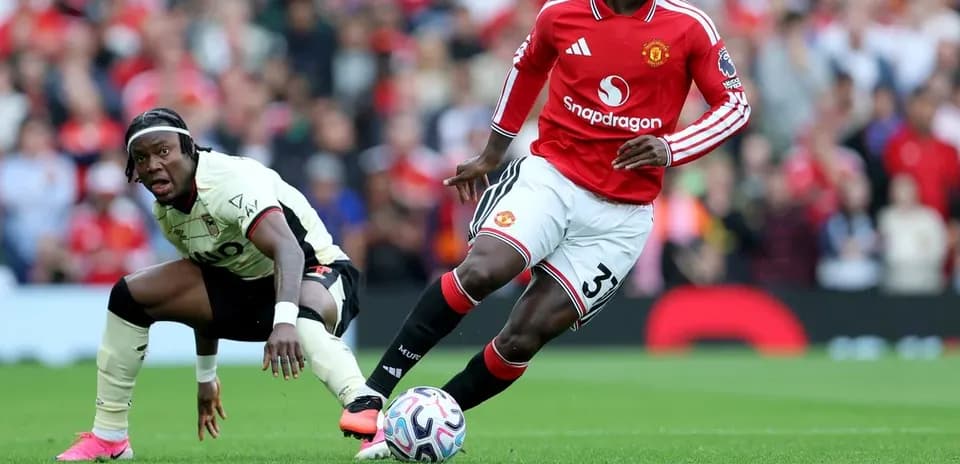 Manchester United player dribbling past opponent on pitch