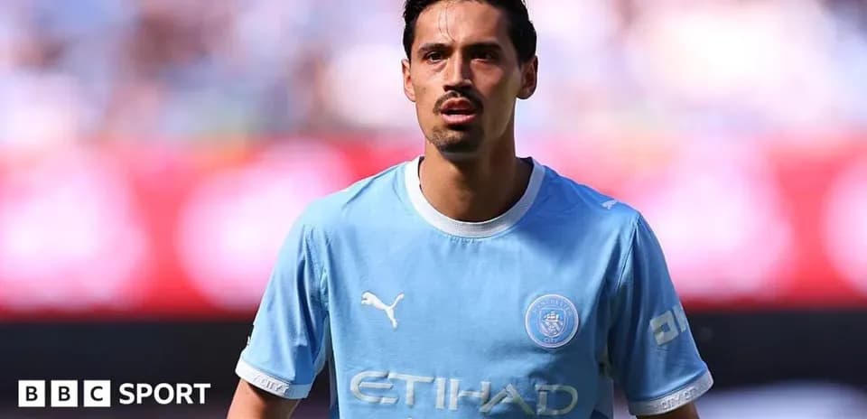 Player in light blue Manchester City kit on pitch