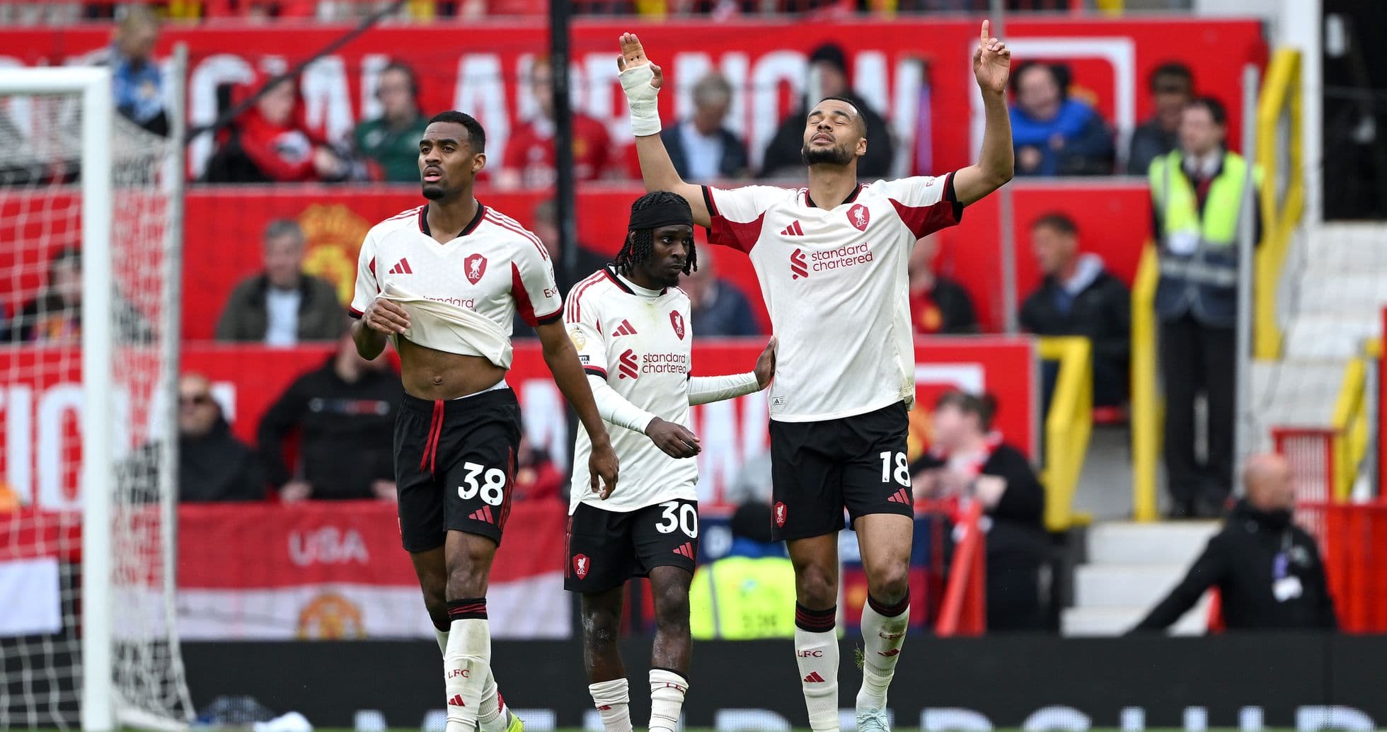 Three players celebrating on the pitch after match