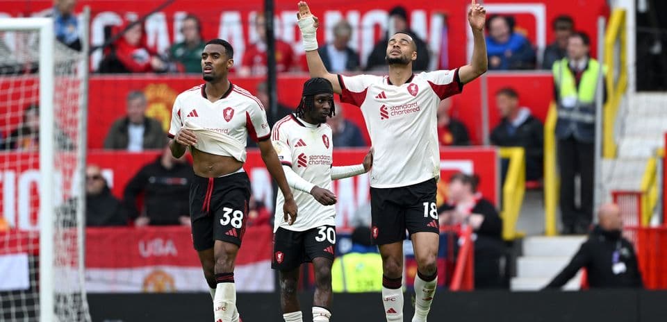 Three players celebrating on the pitch after match