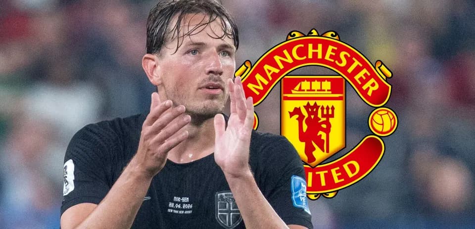 Player in black jersey applauding with Manchester United logo