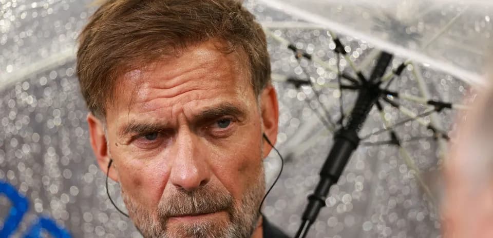 Manager under an umbrella during press conference