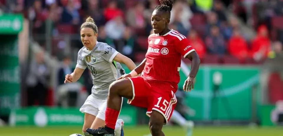 Player in red dribbling past opponent in green