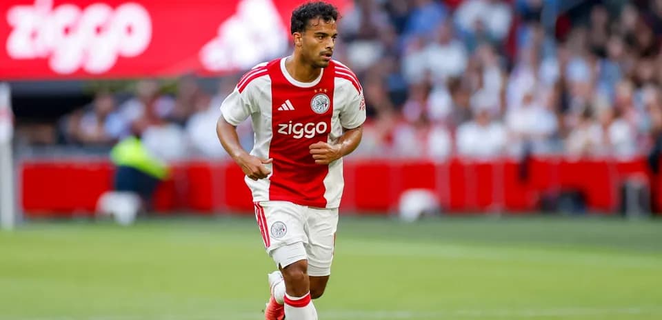 Player in Ajax kit running with ball on field