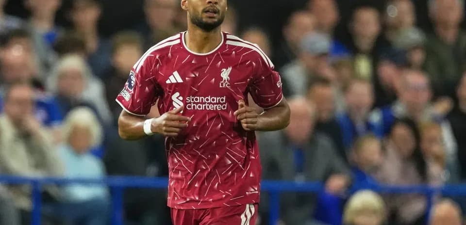 Liverpool player running during match in red kit