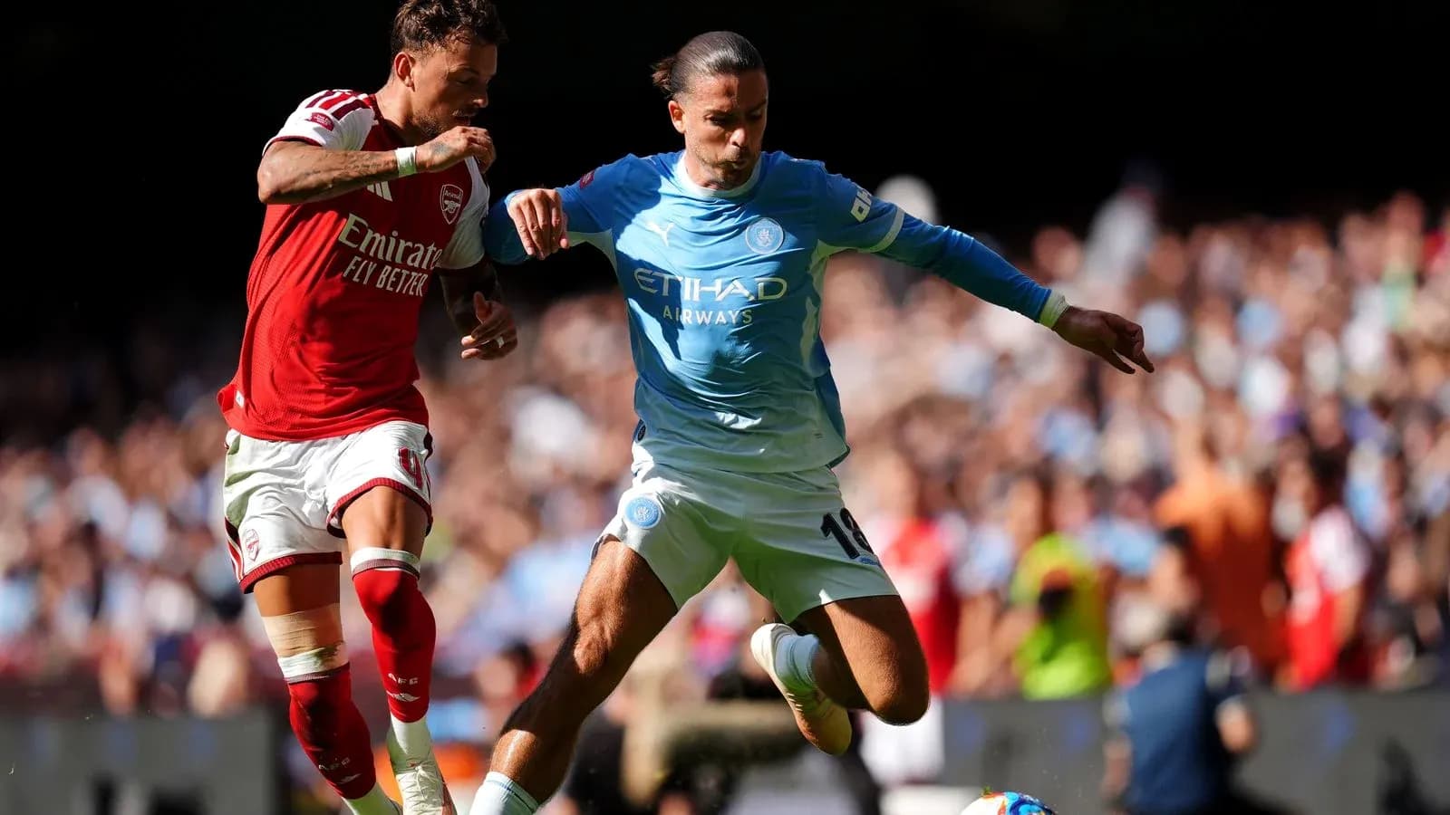 Arsenal and Manchester City players contesting the ball