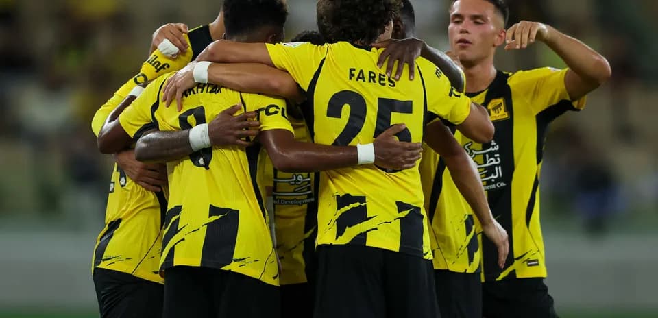 Players celebrating a goal in team jerseys