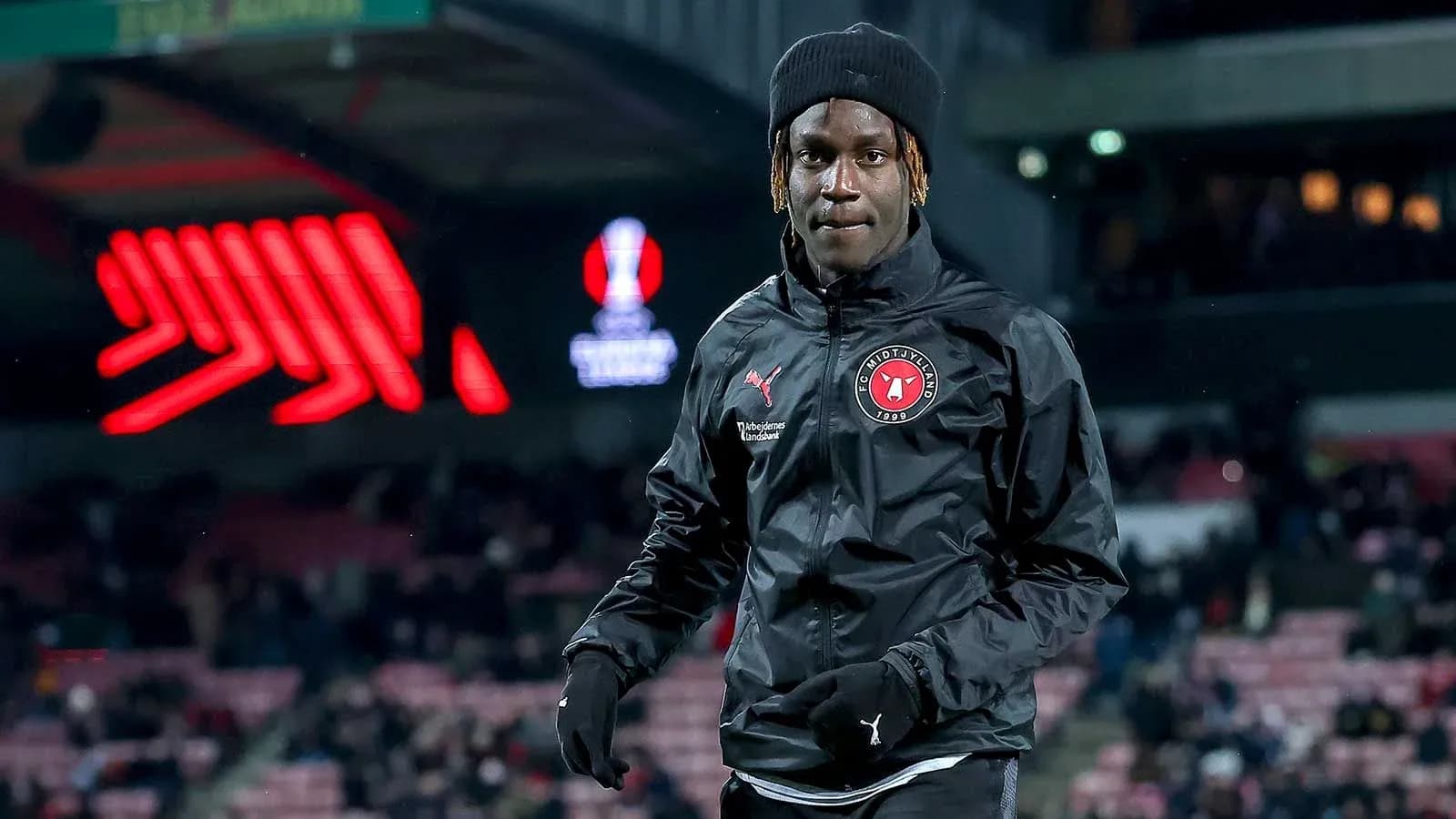 Player walking on pitch in FC Midtjylland jacket