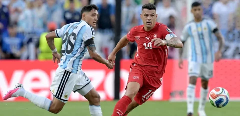 Argentinian player chasing Swiss player with ball