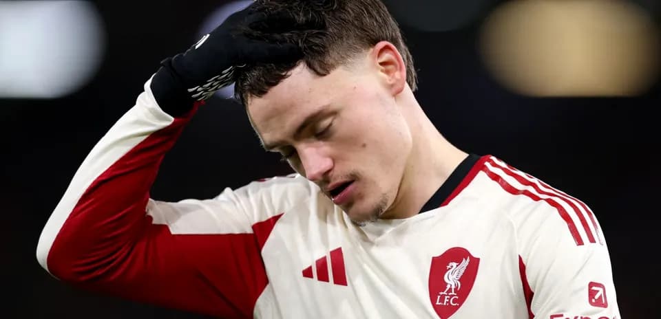 Player in Liverpool kit holding head in disappointment