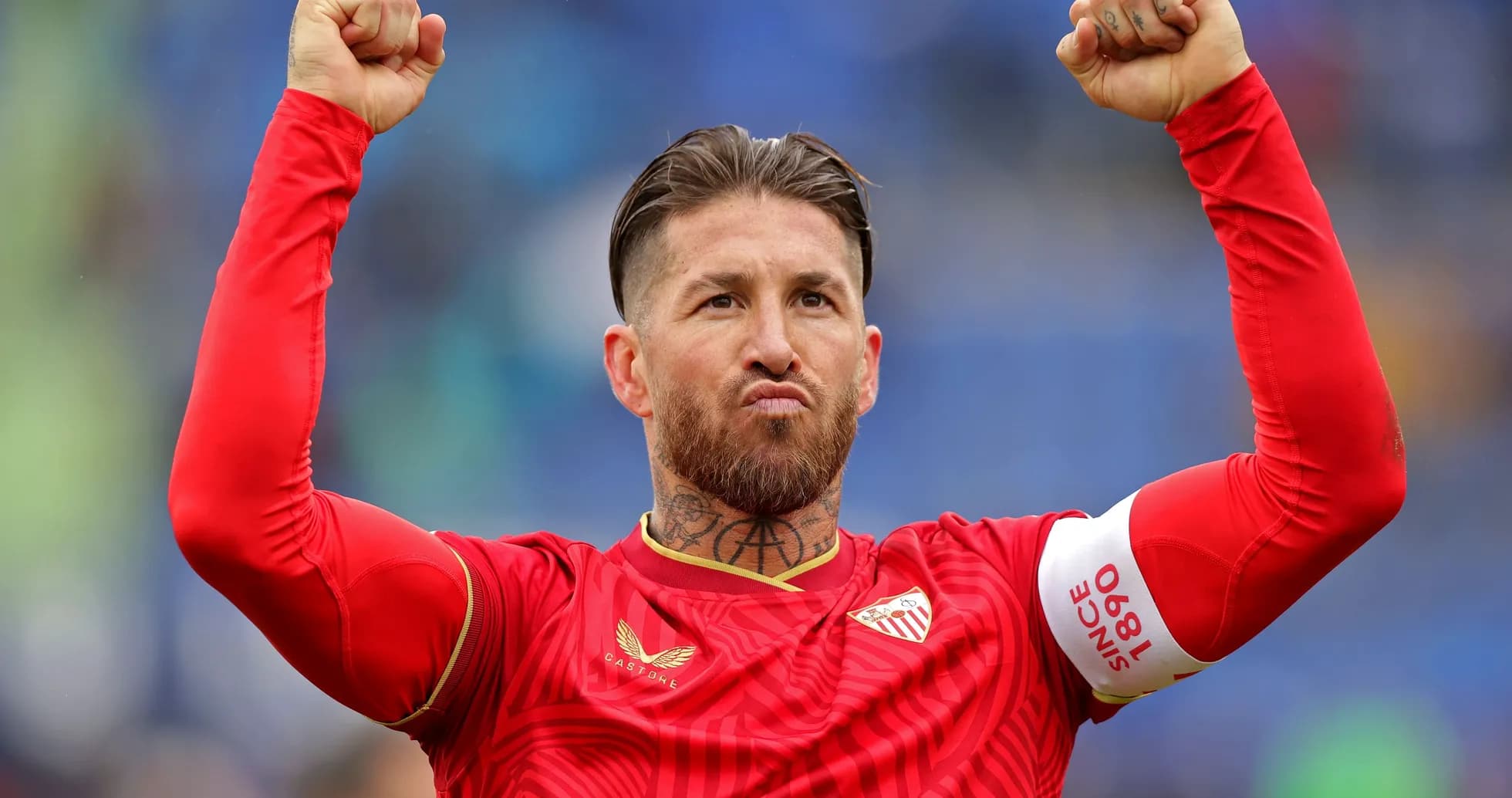 Player celebrating with raised fists in red jersey