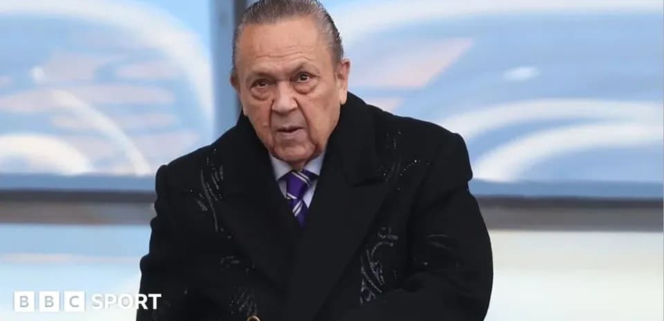 Man in a coat at a sporting event