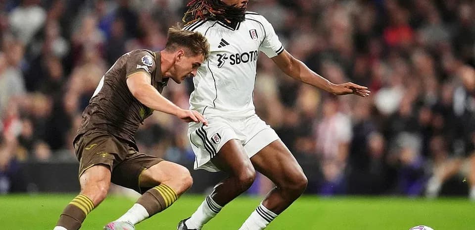 Brentford player tackling Fulham player during match