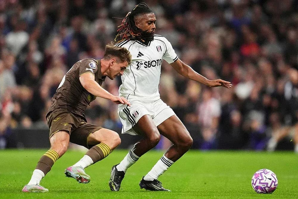 Brentford player tackling Fulham player during match
