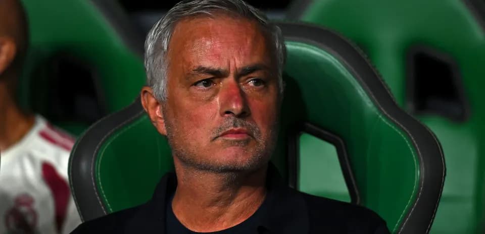 Manager seated on bench during a match