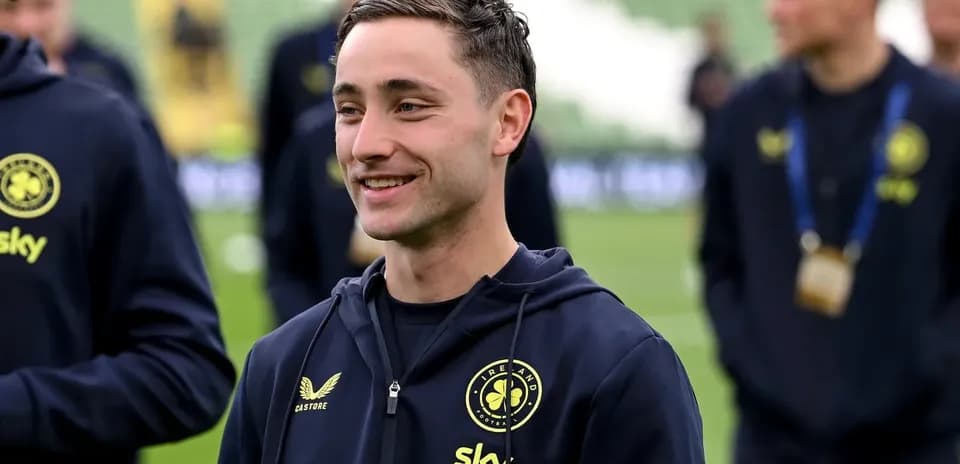 Player smiling while warming up on the pitch
