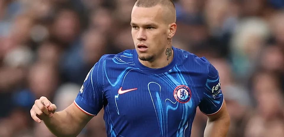 Player in blue Chelsea jersey running on pitch