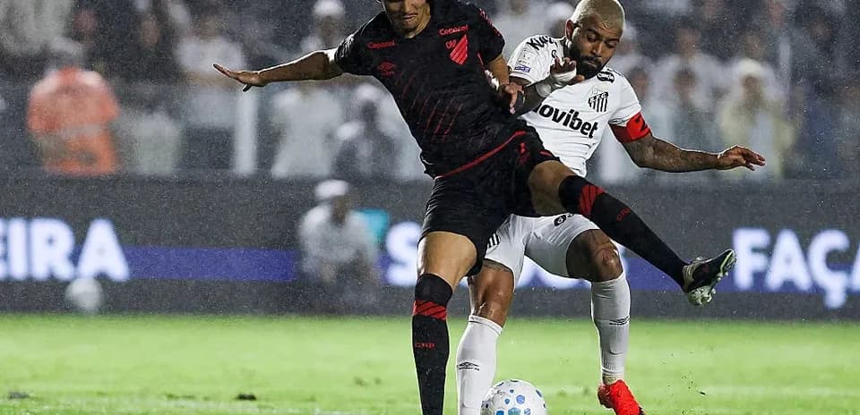 Two players battling for the ball in rain