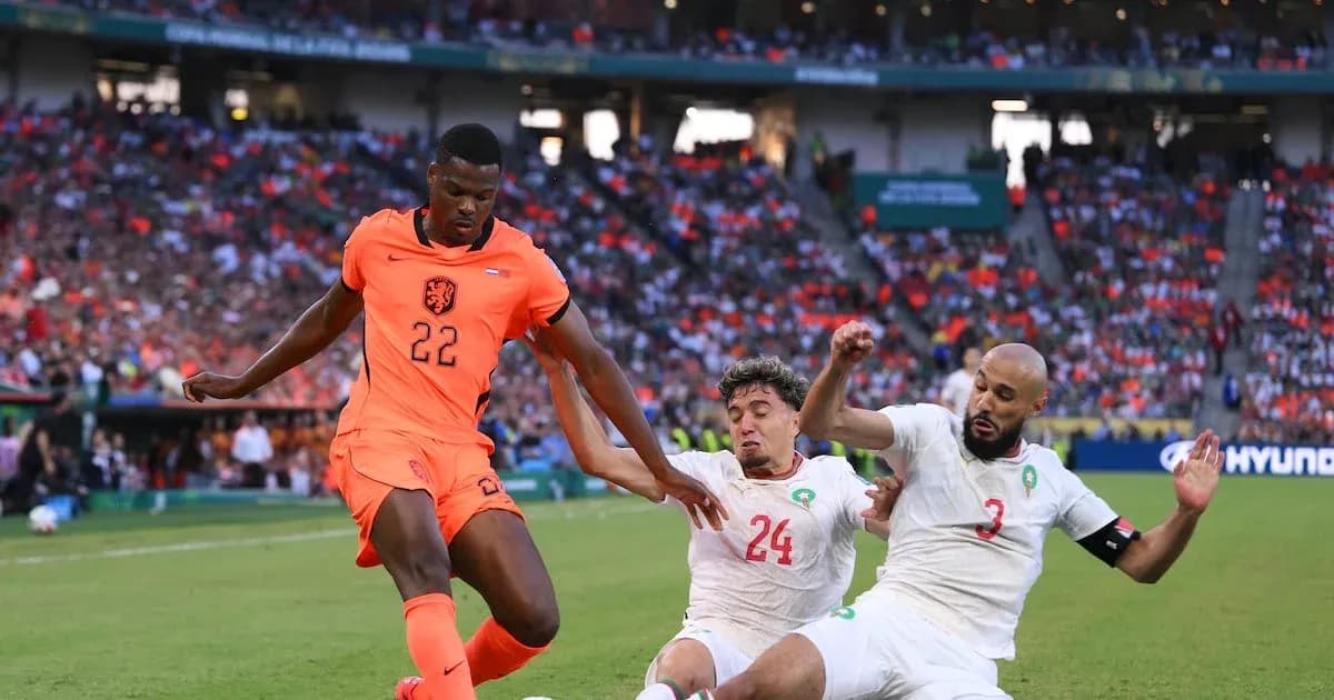 Player 22 from Netherlands evading two Moroccan defenders