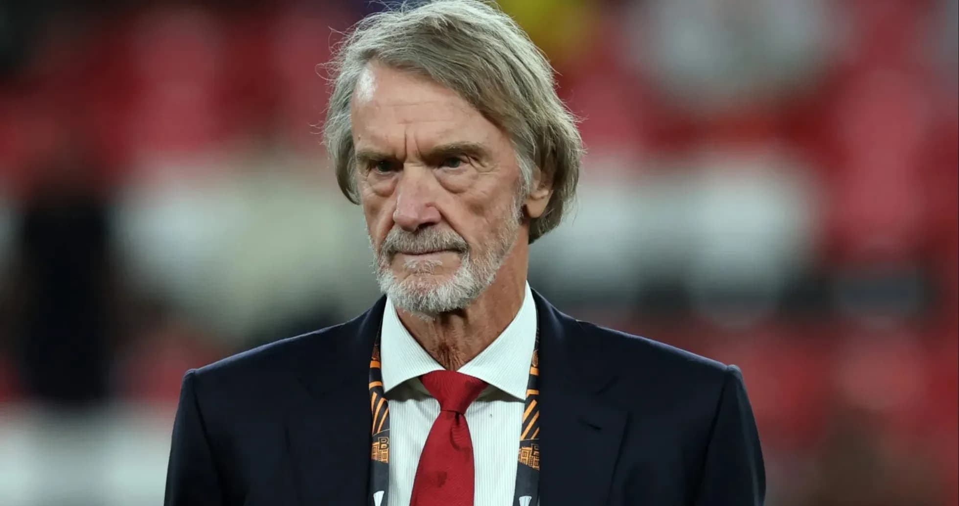 Man in suit with red tie at stadium