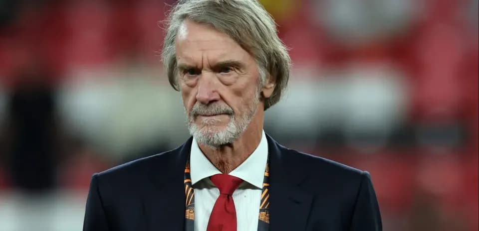 Man in suit with red tie at stadium