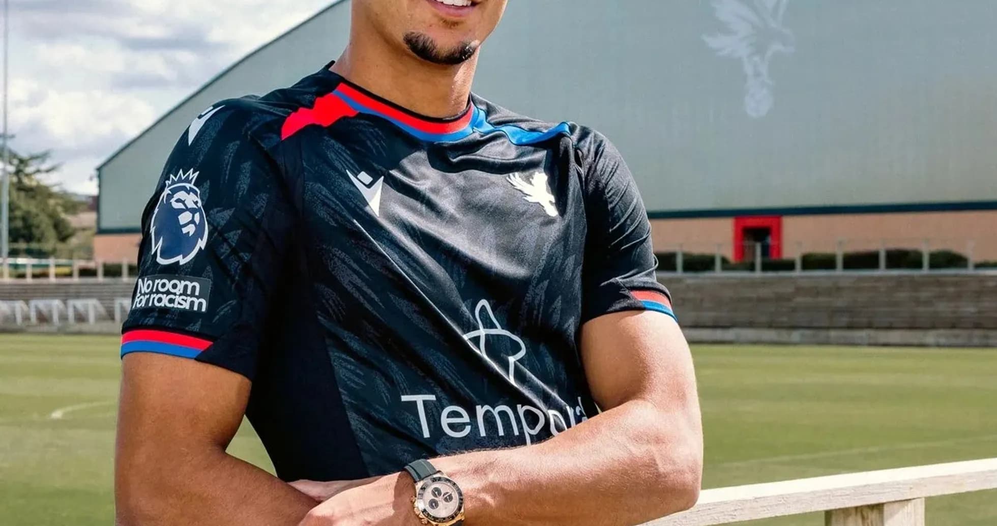 Player posing in training kit at football pitch