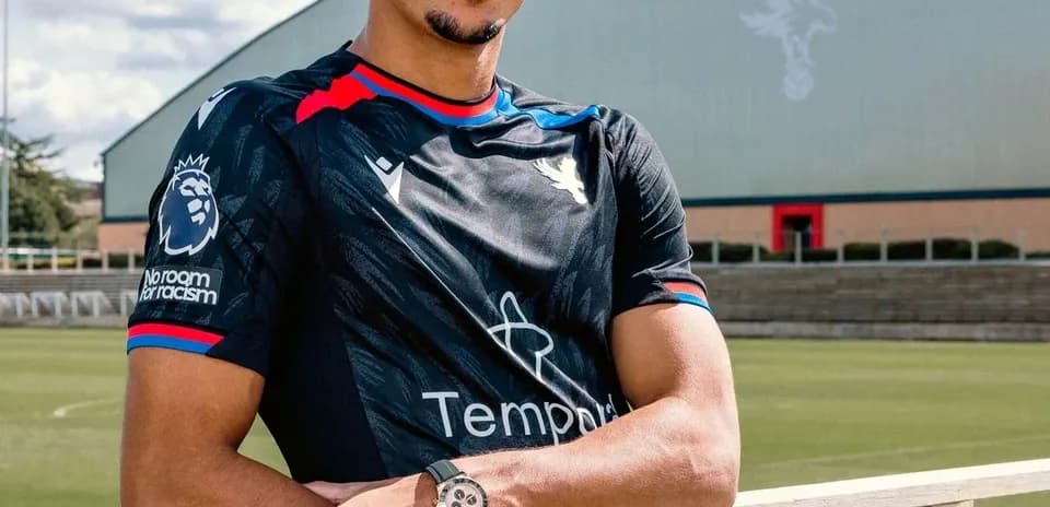 Player posing in training kit at football pitch