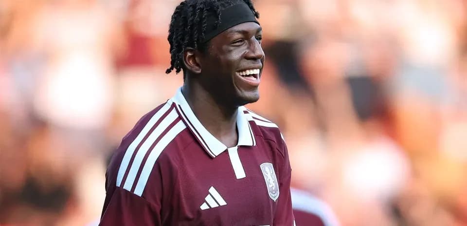 Player smiling in maroon team jersey during match