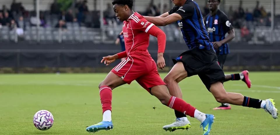 Player in red sprinting past opponent in blue