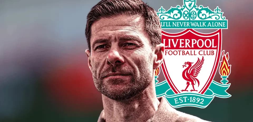 Man standing in front of Liverpool FC logo