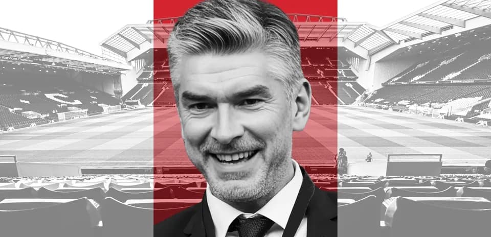 Man smiling in front of a football stadium