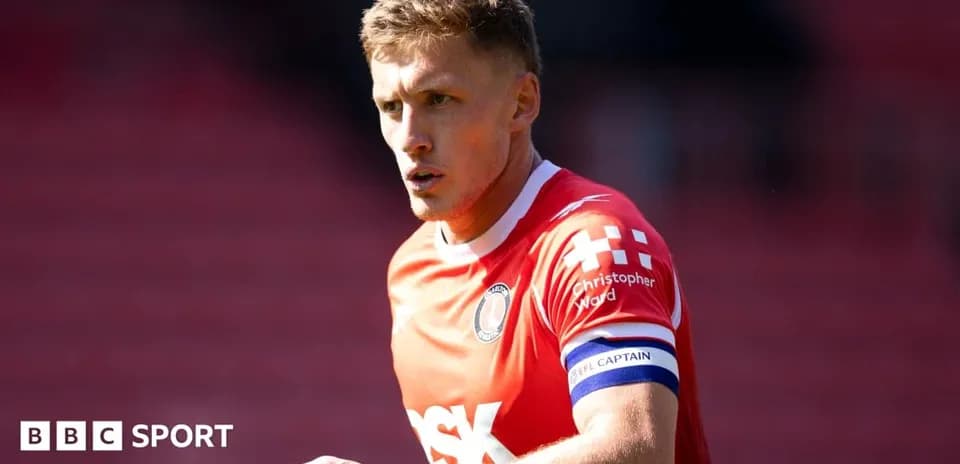 Player in red jersey with captain armband during match