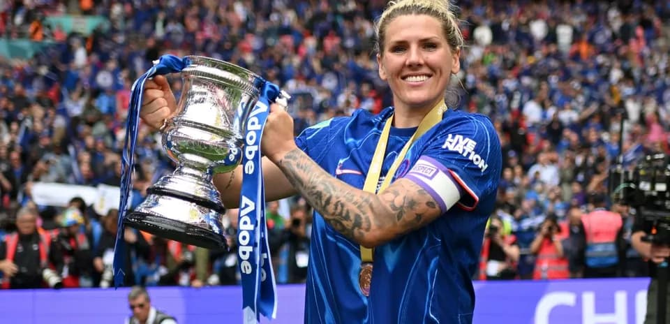 Player celebrating with trophy in front of fans