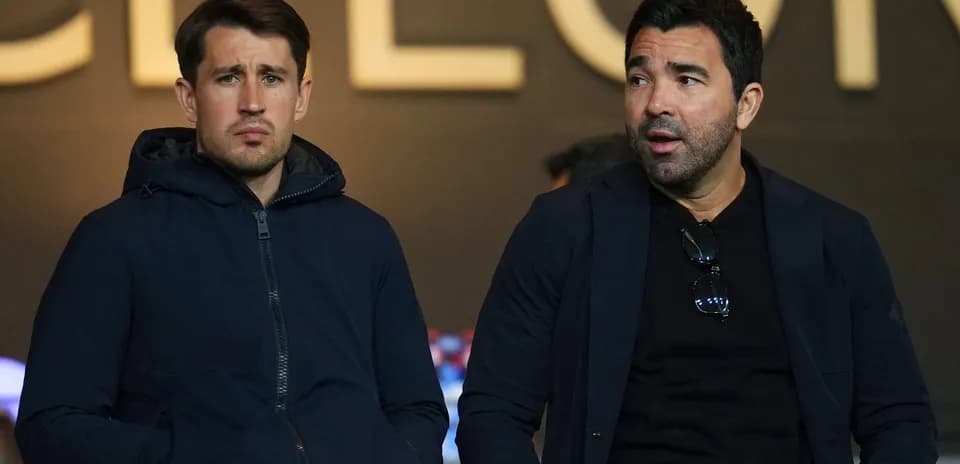 Two men sitting in stadium during a match