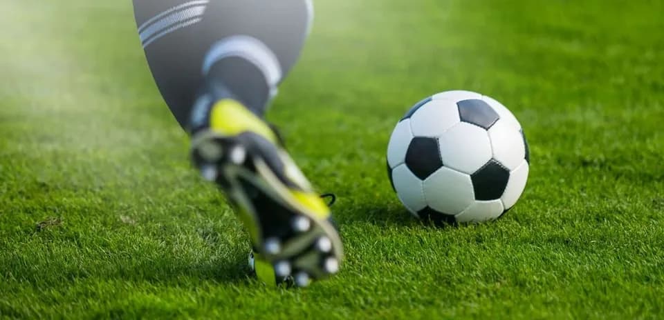 Player kicking a soccer ball on the field