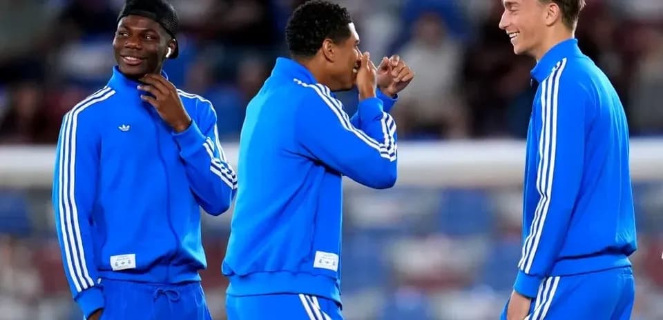 Three players in blue tracksuits laughing together