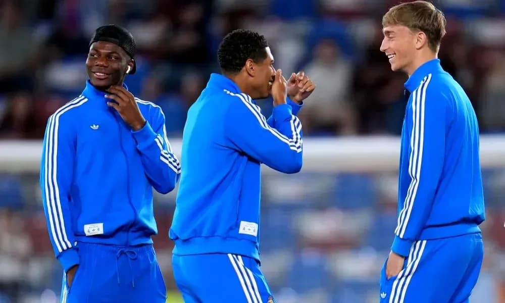 Three players in blue tracksuits laughing together