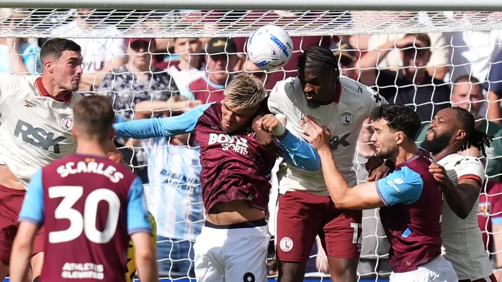 Players contesting a header near the goal line