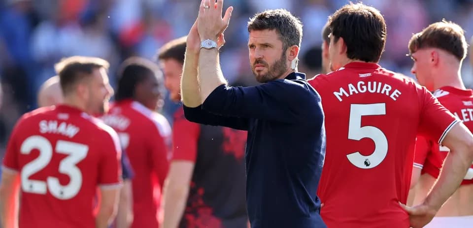 Coach applauding players after match, team in red
