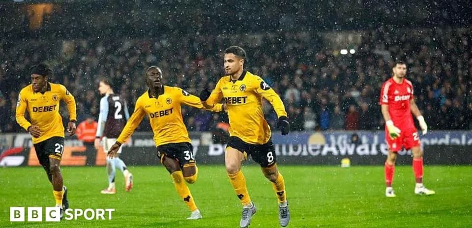 Players celebrating a goal during a rainy match