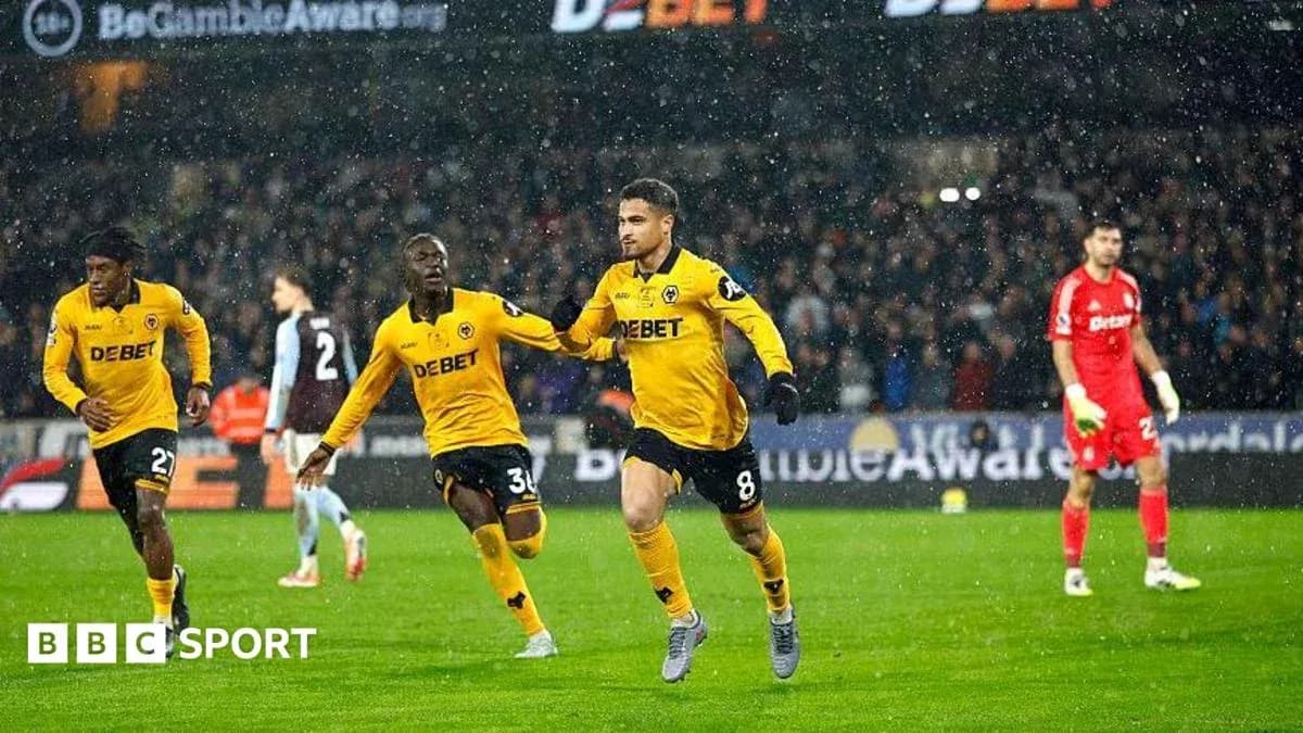 Players celebrating a goal during a rainy match