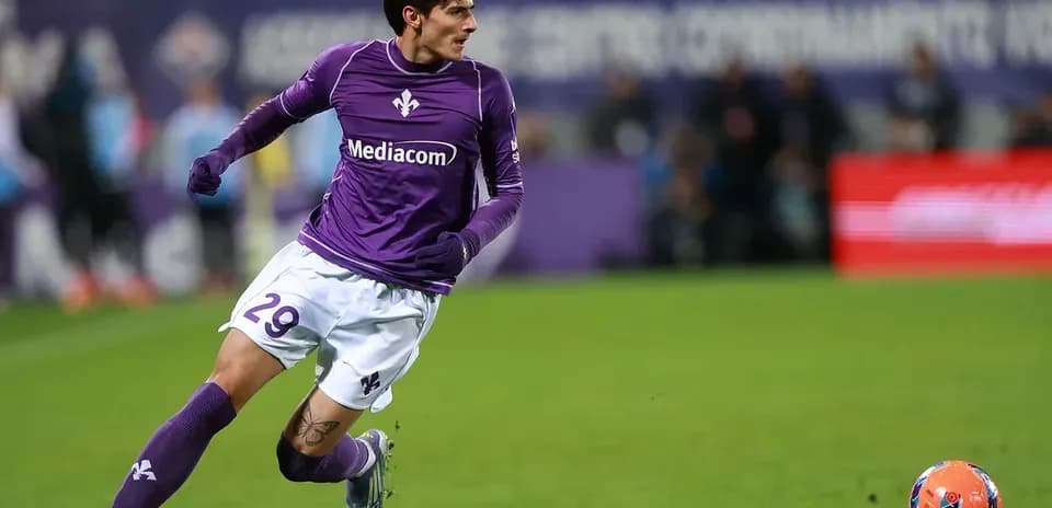 Player in purple jersey running after a soccer ball