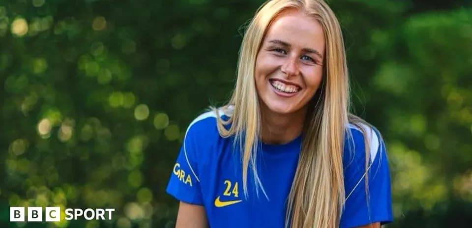 Female player smiling in blue team jersey