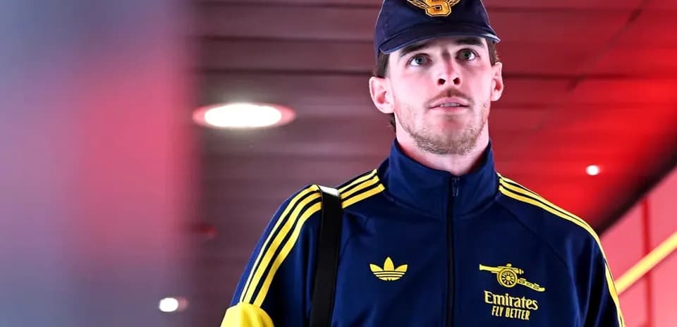 Player in Arsenal tracksuit walking through corridor